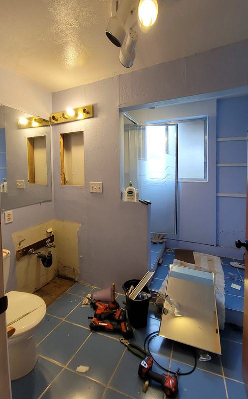 The original bathroom with blue tile and dated fixtures